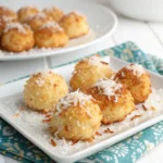 Golden keto coconut clusters topped with shredded coconut, served on a white plate.