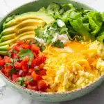Mexican fiesta keto breakfast bowl with scrambled eggs, cheese, and avocado - 245 calories, 23g protein