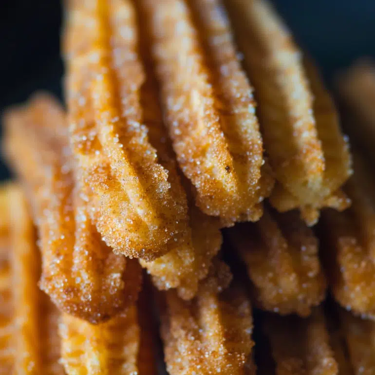 Close-up of churro ridged texture with cinnamon sugar coating showing crispy exterior