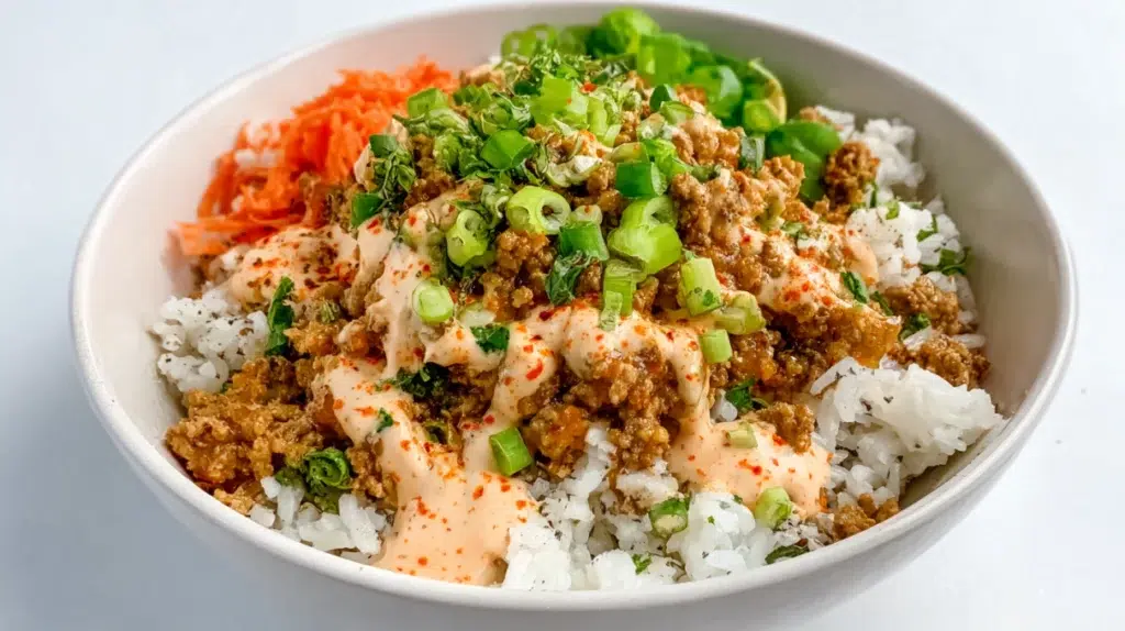 Bang Bang ground turkey rice bowl topped with creamy spicy sauce and green onions