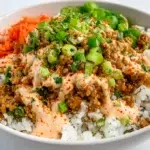 Bang Bang ground turkey rice bowl topped with creamy spicy sauce and green onions
