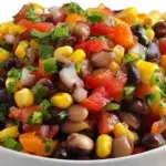 Colorful cowboy caviar made with black beans, corn, tomatoes, avocado, and fresh herbs