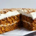 Moist sourdough discard carrot cake topped with creamy cream cheese frosting and chopped nuts